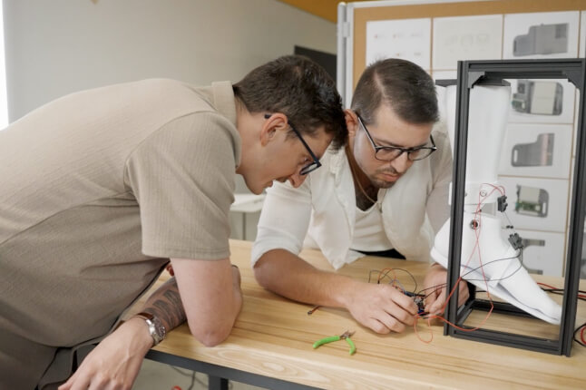 Harvard SEAS alums Viktor Bokisch and Bradley Wagman working on a robotic sock