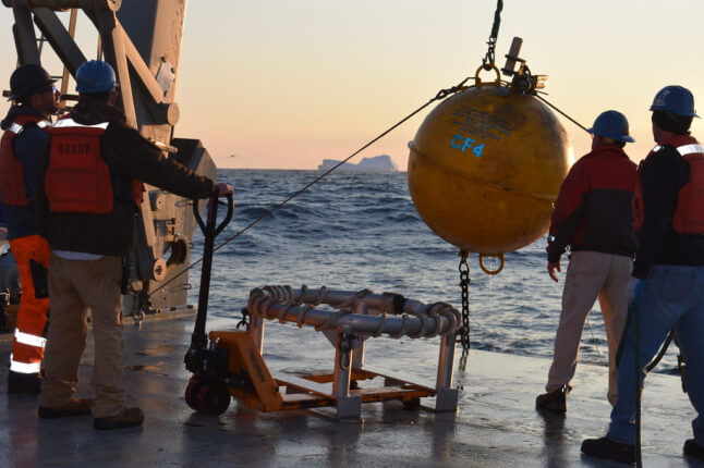 Scientists recovering spherical monitoring device