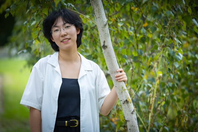 Harvard SEAS student Luna Yin standing next to a tree