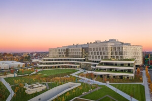 The SEC, pictured in front of a horizon of purple and orange, features a massive green space outside known as the Engineering Yard.