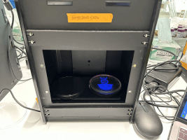 A blue light emitter projects an image onto a petri dish