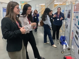 Graduate students looking at research posters