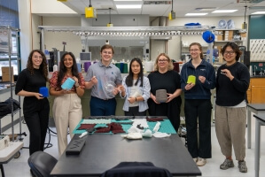 Harvard SEAS alum Vanessa Sanchez with Rice University students holding yarn in a lab