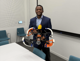 Harvard SEAS student Michael Awah holding a propellered vehicle