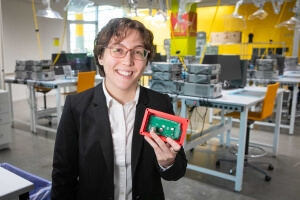 Harvard SEAS student Bella Pignataro holding an electronic circuit board