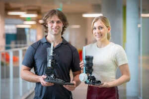 Harvard SEAS students David Picard and Cooper Knarr holding two motorized ankle exoskeletons
