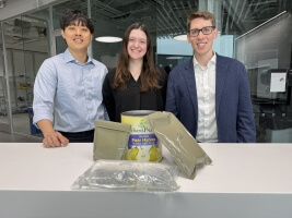 Harvard SEAS students Ray Noh, Faith Schmidt and Josh Halberstadt behind a set of rations pouches and a can of pears