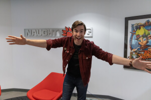 Harvard SEAS alum Grant Hoechst Jackson, A.B. '18, in front of a sign for Naughty Dog gaming studio