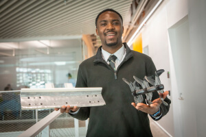 Harvard SEAS student Tolu Ademola holding his senior project