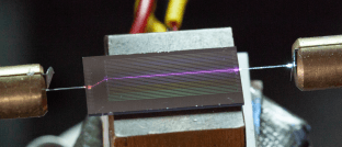 Camera image of the sidewall-poled lithium niobate chip during UV generation.